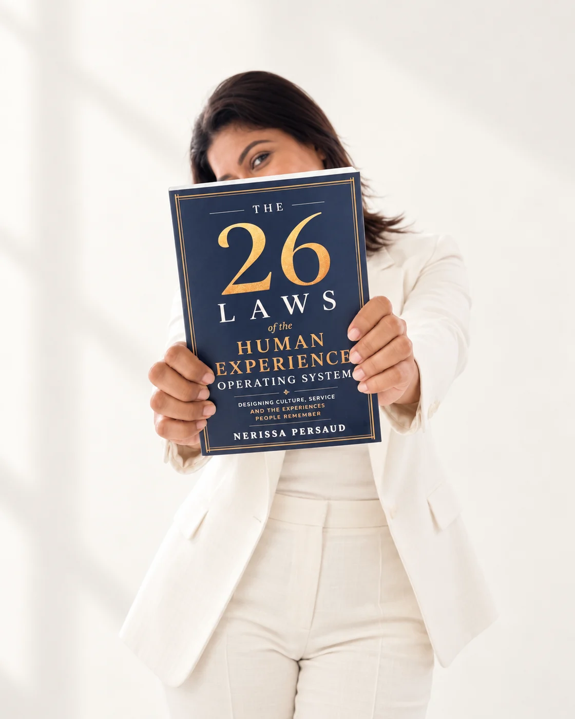 Nerissa Persaud holding The 26 Laws of the Human Experience Operating System towards you