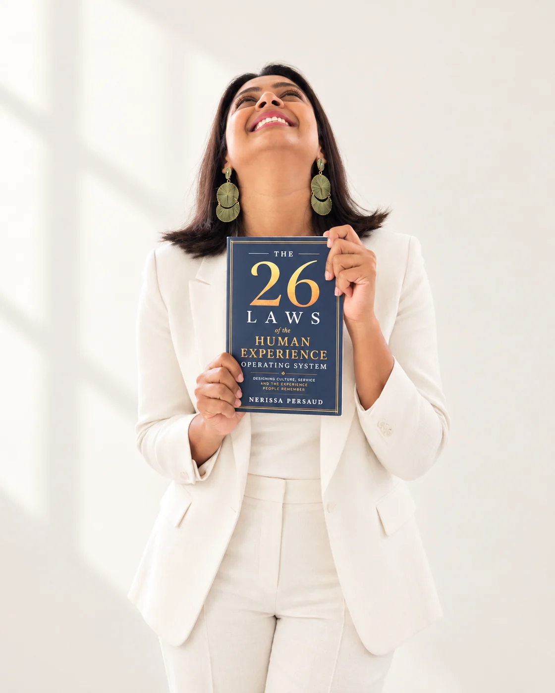 Nerissa Persaud smiling upwards while holding her book